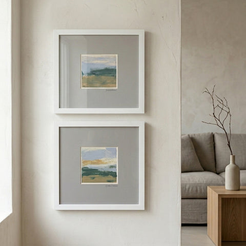 Two framed artworks on a wall above a sofa in a living room.